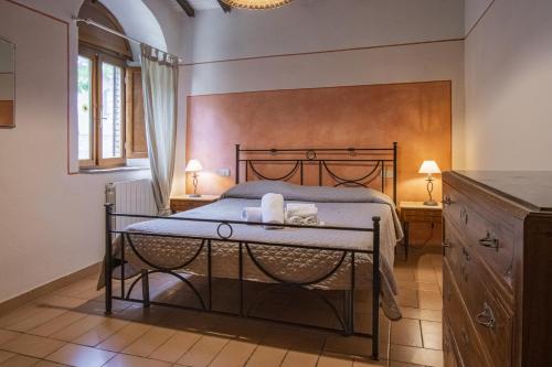 1 dormitorio con 1 cama y 1 mesa con 2 lámparas en Agriturismo Fattoria Lischeto, en Volterra