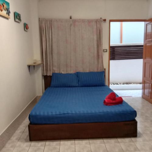 a bedroom with a blue bed with a window at Plaza Huahin in Hua Hin
