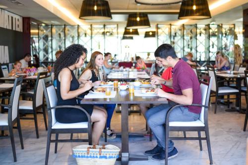 un grupo de personas sentadas en una mesa en un restaurante en Aquashow Park Hotel, en Quarteira