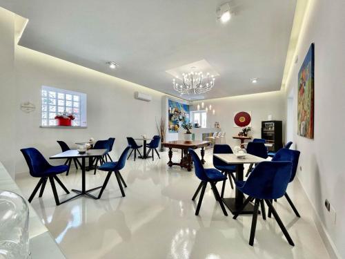 a dining room with blue chairs and tables at Tribus Boutique Hotel in Torre Annunziata