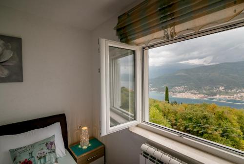 a bedroom with a large window with a view at Apartments Mitrovic in Lustica
