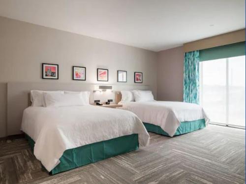 Cette chambre comprend 2 lits et une fenêtre. dans l'établissement Hilton Garden Inn Visalia, Ca, à Visalia