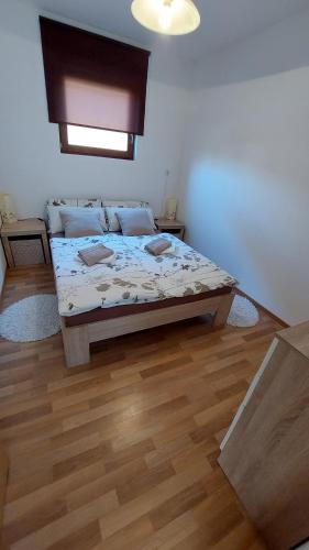 1 dormitorio con 1 cama y suelo de madera en Zidanica Lan, en Lendava