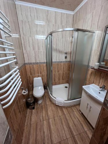 a bathroom with a shower and a toilet and a sink at Готель Баронський Двір in Chernivtsi