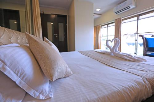 a white bed with a swan decoration on it at Gulf Hotel Mumbai- The Boutique Hotel Colaba Mumbai in Mumbai