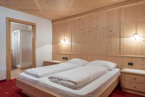 Ένα ή περισσότερα κρεβάτια σε δωμάτιο στο Hotel Residence Gardena Dolomites 2