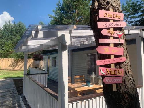 ein Schild, das an einem Baum vor einem Haus befestigt ist in der Unterkunft Domki na Kwiatowej Okuninka - Orchówek in Orchówek