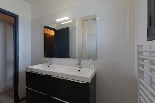 une salle de bain avec un lavabo blanc et un miroir dans l'établissement LE BEAULIEU * Appartement 4 chambres * 8pers * Clim * Parking * Balcon, à Montpellier
