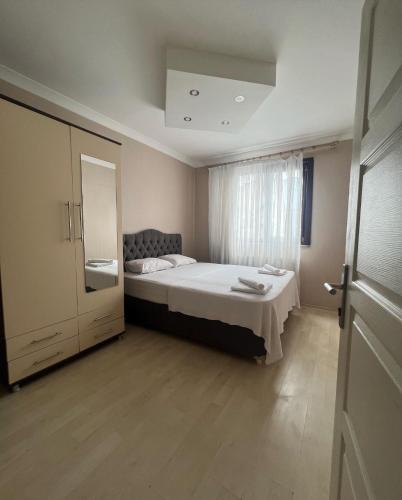 a small bedroom with a bed and a window at Hypatia Apt in Trabzon