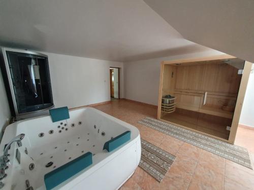a large white tub in a room with a kitchen at Pensiune Restaurant Cosna in Coşna