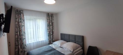 a bedroom with a bed and a window at Przystanek Solina in Solina