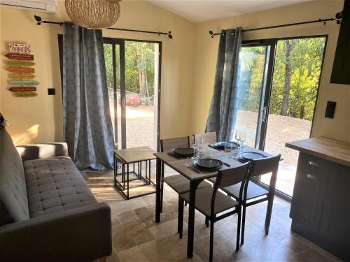 un salon avec une table, des chaises et un canapé dans l'établissement Appartement de charme avec jaccusi, à Vézénobres