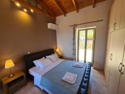 a bedroom with a large bed with a window at Leopolis Villas in Stoupa