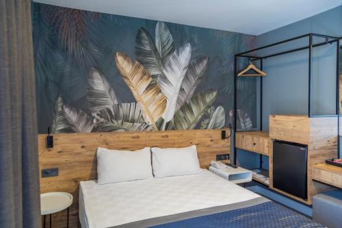 a bedroom with a bed and a mural of feathers at Pure Blanche Hotel in Antalya