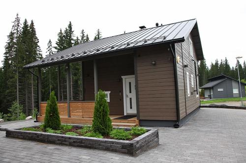 a small house with a roof on a patio at Himos Villa Nummenranta 1 in Jämsä