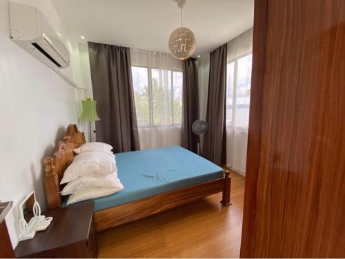 a bedroom with a blue bed and a window at RLJ Beach House in Naval