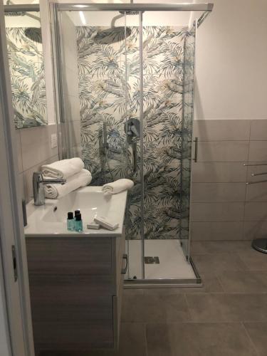 a bathroom with a shower with a sink and a mirror at Le 5 Residence in Rodi Garganico