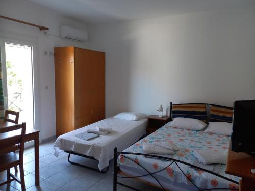 a bedroom with a bed and a dresser in it at Apartment Kasperakos in Skiathos Town