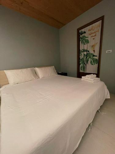 a bedroom with a large white bed in a room at Donggang Homestay-Dongfan in Donggang
