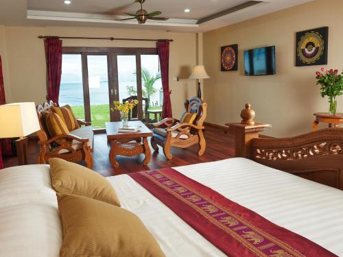 Sara Beachfront Boutique Resort في Pathiu: غرفة نوم مع سرير وغرفة معيشة