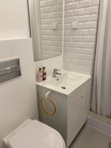 a white bathroom with a sink and a toilet at Balaia I in Olhos de Água