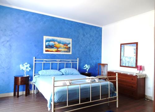 um quarto com paredes azuis e uma cama e um espelho em Appartamento Mariella em Pachino