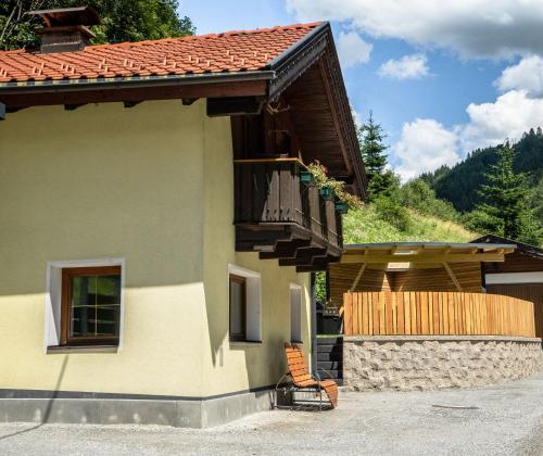 a house with a chair sitting outside of it at Ferienhaus Leite Häusl in Sankt Jodok am Brenner