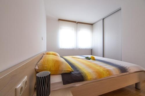 a bedroom with a bed with yellow pillows at Villa Novak in Okrug Donji