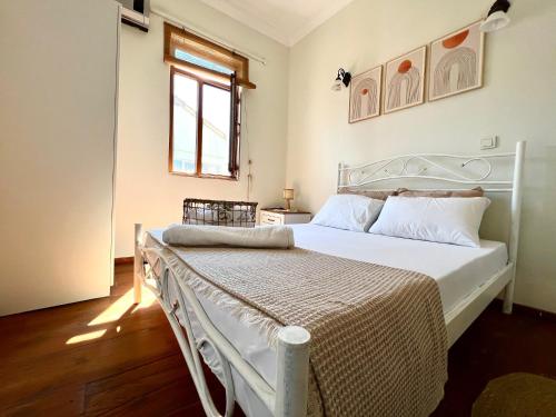 sypialnia z białym łóżkiem i oknem w obiekcie Hygge Ayvalık w mieście Ayvalık