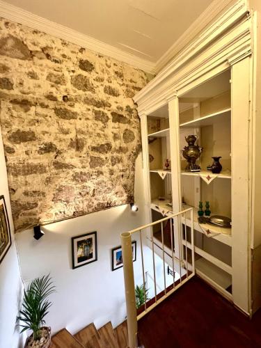 a staircase in a building with a stone wall at Hygge Ayvalık in Ayvalık
