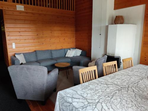 sala de estar con sofá, mesa y sillas en Kärpänrinne A, en Syöte