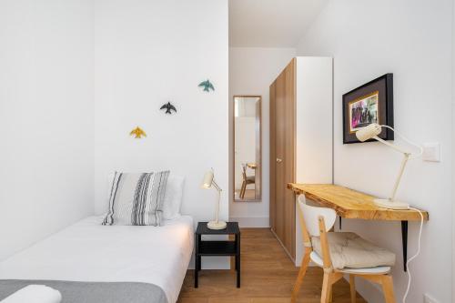 a bedroom with a bed and a desk with a table at Modern Lisbon Apartments by Soulplaces in Lisbon
