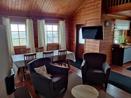 ein Esszimmer mit einem Tisch, Stühlen und einem TV in der Unterkunft Kärpänrinne A in Syöte