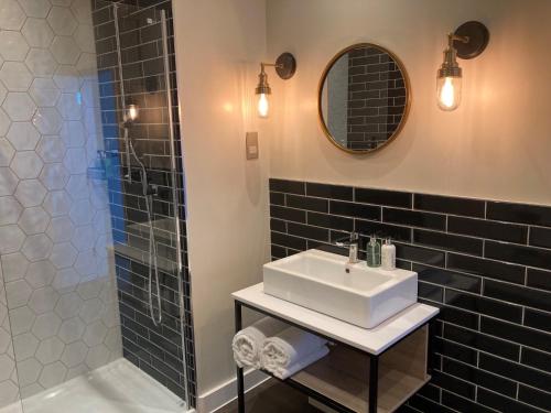 a bathroom with a sink and a shower at Downs Hotel in Stanmer