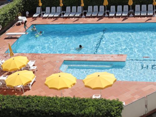 una vista sul tetto di una piscina con ombrelloni gialli di Hotel Graziella a Rimini