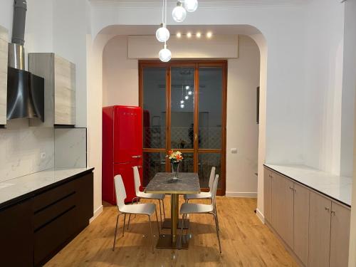 a kitchen with a table with chairs and a red refrigerator at La Villa bed & breakfast in Milan
