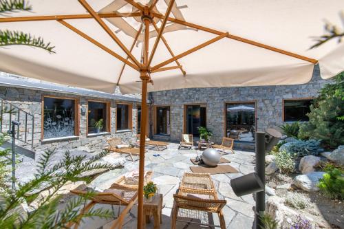 a patio with chairs and an umbrella at Hôtel de Verbier SUP in Verbier