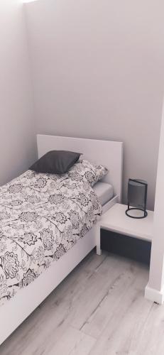a white bed with a black and white comforter at Apartament Kaja in Siemianowice Śląskie