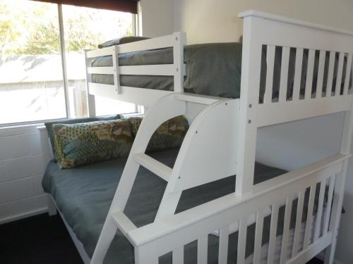 a white bunk bed in a room with a couch at Bellevue on Bentley - Unit 2 in Bridport