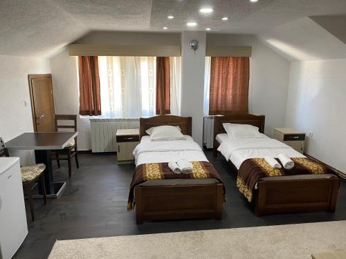 een hotelkamer met 2 bedden en een tafel bij Apartmani Ambiente in Plav