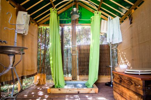 an outside shower with green curtains in a room at Figueirinha Ecoturismo in Montes da Estrada