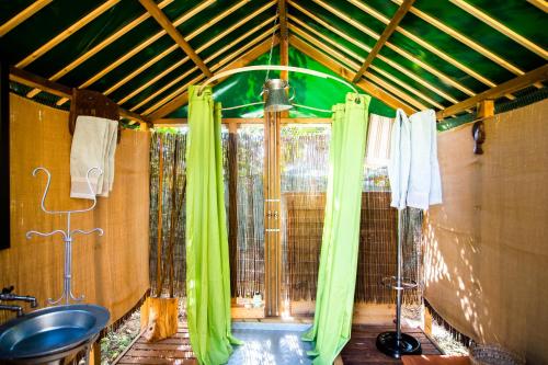 baño con cortinas verdes y lavamanos en Figueirinha Ecoturismo, en Montes da Estrada
