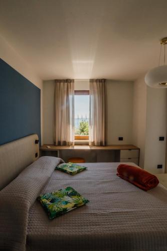 a bedroom with a bed with two pillows on it at Welcome Traveller LA CASA DEGLI ACQUERELLI in Garda