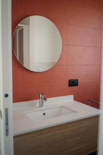 a bathroom with a white sink and a mirror at Welcome Traveller LA CASA DEGLI ACQUERELLI in Garda