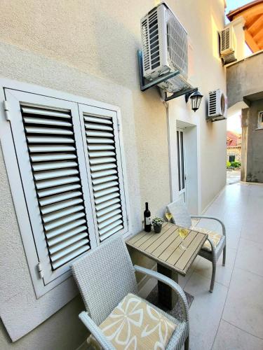 a patio with a table and chairs next to a building at Apartment Dora in Dubrovnik