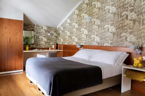 a bedroom with a bed with a floral wallpaper at Hotel Tremoggia in Chiesa in Valmalenco