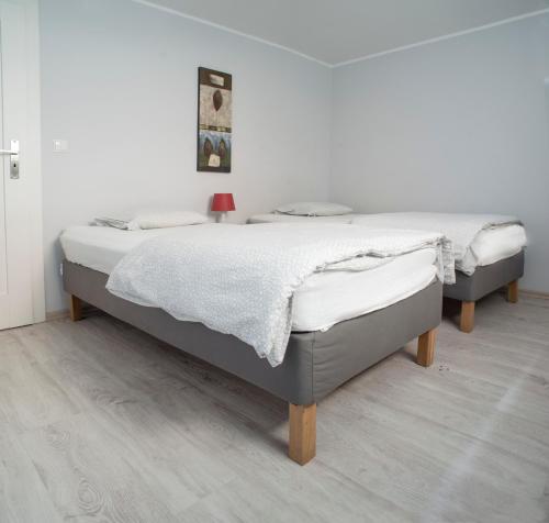 2 łóżka w sypialni z białą ścianą w obiekcie Willa Na Nehringa w Poznaniu