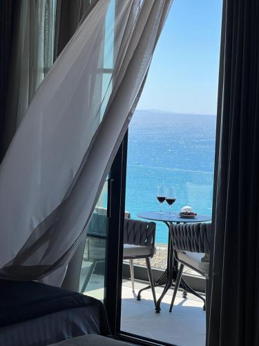 a room with a view of the ocean from a window at Rozafa Palace Hotel in Sarandë