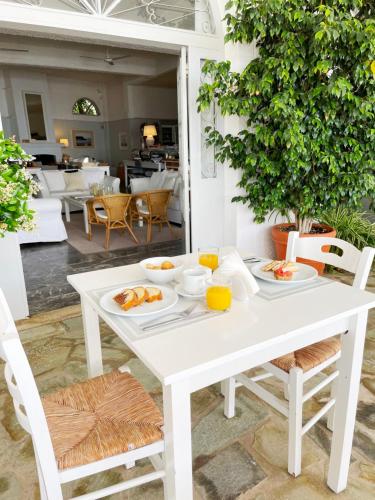 a white table with plates of food on it at Paradisos Hotel in Áyioi Pándes