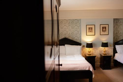 - une chambre avec un lit et deux lampes murales dans l'établissement The Pembroke Arms, à Salisbury